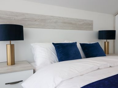 A bedroom featuring a bed with pillows and lamps at The Gavel in Morpeth