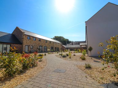 A garden area with buildings and pathway at The Gavel in Morpeth
