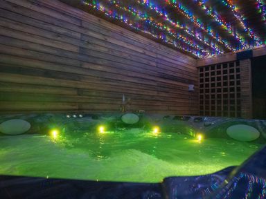 A hot tub with lights and wooden walls at The Gavel in Morpeth