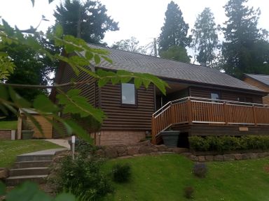 A cabin with deck and landscaped garden at Gowrie Lodge in Blairgowrie