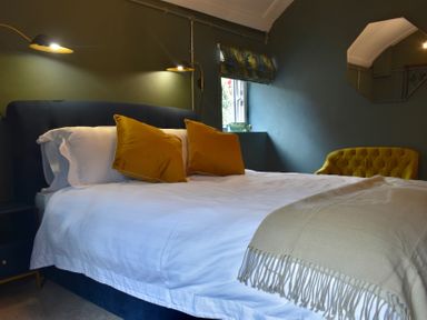 A bedroom with a bed and a chair at Ty Llaeth in Carmarthen
