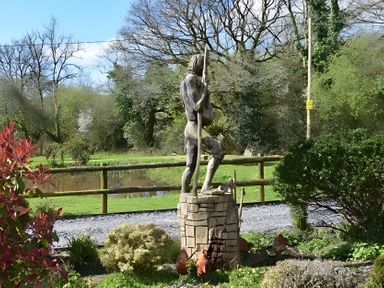 A statue in a garden near a pond at Ty Llaeth in Carmarthen