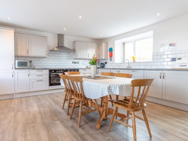 A kitchen with a dining table and chairs at Groeslon Uchaf in Caernarfon