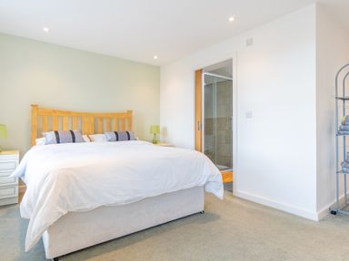 A bedroom with a bed and bathroom entrance at Groeslon Uchaf in Caernarfon