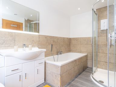 A bathroom with a sink, bathtub, and shower at Groeslon Uchaf in Caernarfon