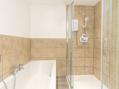 A bathroom with a bathtub and shower at Groeslon Uchaf in Caernarfon