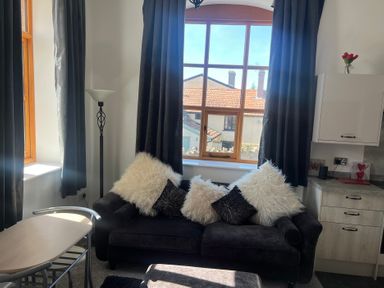 A living room with a sofa and a lamp at 4 Bickington Road Barnstaple