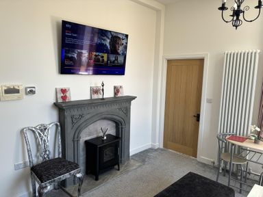 A living room with a television and fireplace at 4 Bickington Road Barnstaple