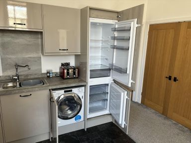 A kitchen with a refrigerator and washing machine at 4 Bickington Road Barnstaple