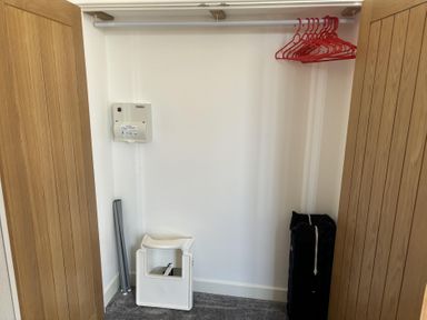 A closet with clothes hangers and a heater at 4 Bickington Road Barnstaple