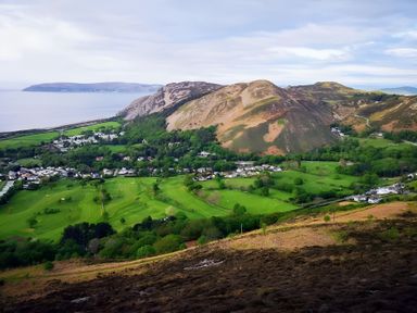 A scenic view of hills and fields near the coast at Blue Haven in Penmaenmawr