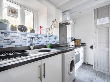 A kitchen with a sink and washing machine at Blue Haven in Penmaenmawr