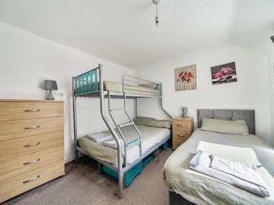 A bedroom with bunk bed and single bed at Blue Haven in Penmaenmawr