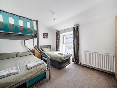 A bedroom with a bunk bed and a double bed at Blue Haven in Penmaenmawr