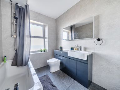 A bathroom with a bathtub, toilet, and sink at Blue Haven in Penmaenmawr
