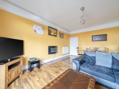 A living room with a television and dining area at Sea View Escape in Penmaenmawr