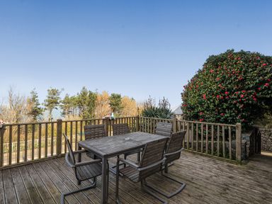 A dining area with a table and chairs on the deck at Sea View Escape in Penmaenmawr