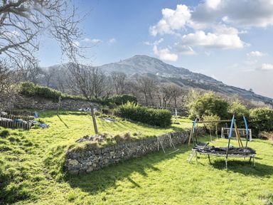 A garden with a trampoline and swing set at Sea View Escape in Penmaenmawr
