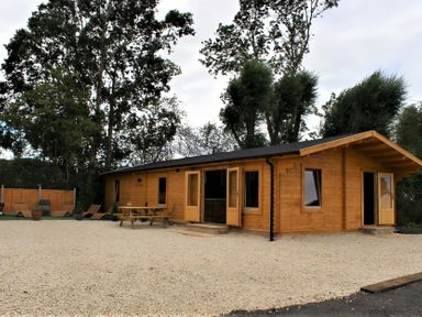 A wooden cabin with a picnic table in an outdoor area at Cotswold Nights Away 1 Evesham