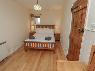 A bedroom with a bed and nightstand at Sunny Brae in Alnwick