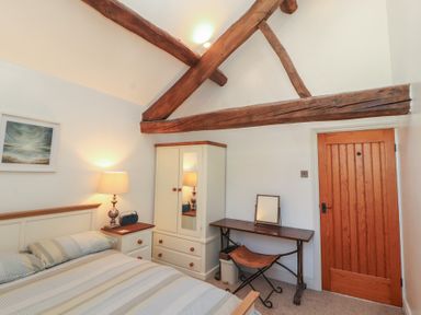A bedroom with a bed and a wardrobe at Tullythwaite Barn in Kendal