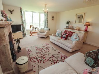 A living room with a sofa and television at Thimble Hill near Armathwaite