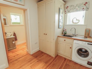 A washroom with a sink and washing machine at Thimble Hill Near Armathwaite