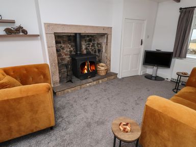 A living room with a fireplace and sofas at 1 Sunnybrae Alnwick