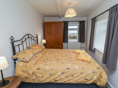 A bedroom with a bed, wardrobe, and window at 1 Sunnybrae in Alnwick