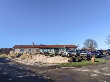 A building with cars parked outside at Harry's Cottage in Embleton