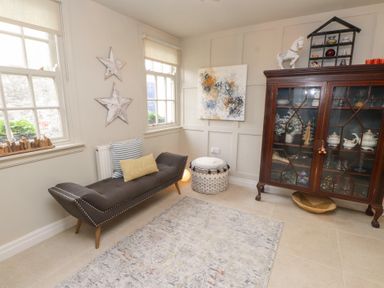 A snug with a sofa and cabinet at The Music Box in Beaumaris