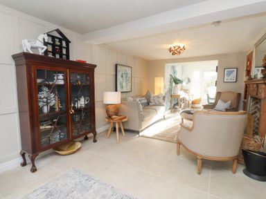 A living room with a cabinet and a sofa at The Music Box in Beaumaris