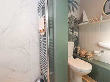 A bathroom featuring a shower, toilet, and washbasin at The Music Box in Beaumaris