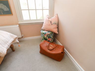 A bedroom with a bag and a cushion in the corner at The Music Box Beaumaris