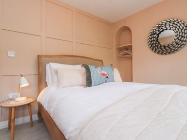 A bedroom with a bed and lamp at The Music Box in Beaumaris