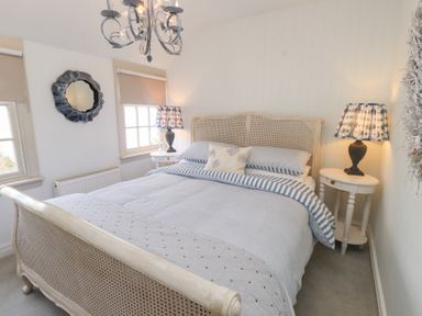 A bedroom with a bed and bedside tables at The Music Box in Beaumaris