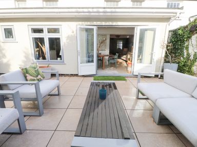 A garden with outdoor seating and a table at The Music Box in Beaumaris