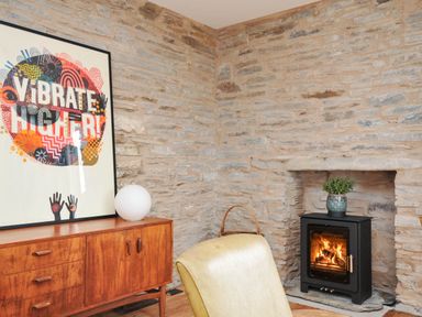 A living room with a fireplace and artwork at Boscabrea near Tintagel