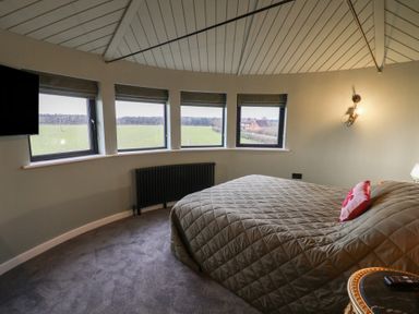 A bedroom with a bed and windows at Unit 1 in Ipswich
