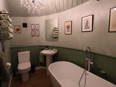 A bathroom with a bathtub, toilet, and sink at Unit 1 Ipswich