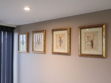 Four framed artworks on a wall at Unit 1 Ipswich