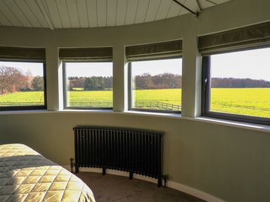 A bedroom with windows and a radiator at The Corn Silo in Ipswich