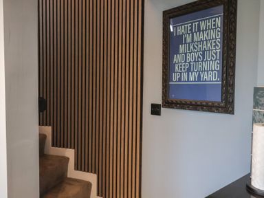 A staircase with wood paneling and framed artwork at Unit 2 in Ipswich