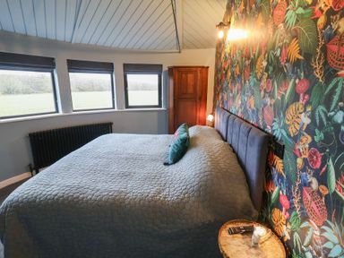 A bedroom with a bed and windows at Unit 2 in Ipswich