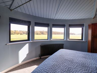 A bedroom with windows and a radiator at The Barley Silo in Ipswich