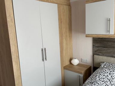A bedroom with a wardrobe and bedside table at TW89 Exmouth
