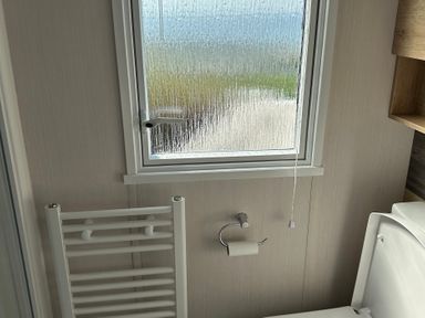 A bathroom with a toilet and towel rail at TW89 Exmouth
