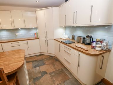 A kitchen with cabinets and appliances at Ty-Gan Dderwen in Llangennech, Llanelli