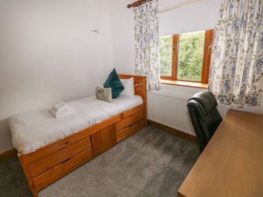A bedroom with a bed and desk at Ty-Gan Dderwen in Llangennech, Llanelli
