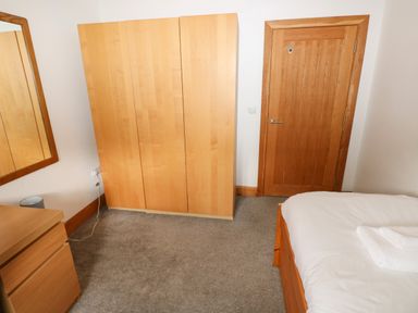 A bedroom with a wardrobe and a mirror at Ty-Gan Dderwen in Llangennech, Llanelli